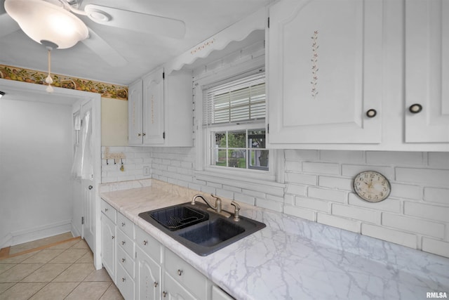 kitchen with a sink, decorative backsplash, and white cabinets