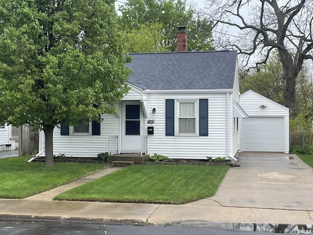 view of front of house featuring driveway, a chimney, roof with shingles, an outbuilding, and a front lawn