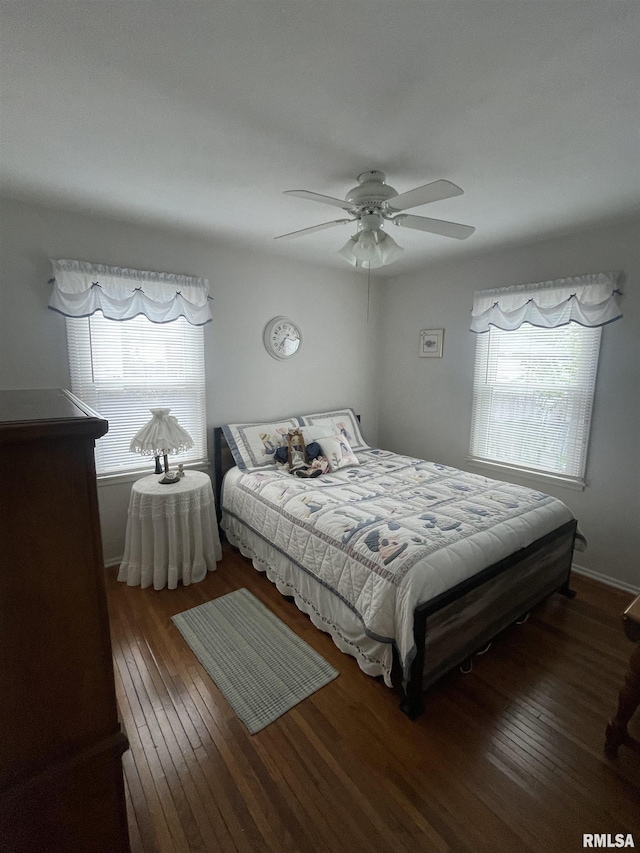 bedroom featuring ceiling fan, multiple windows, and hardwood / wood-style floors