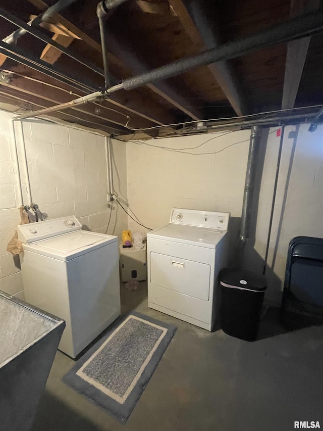 clothes washing area with laundry area, washing machine and dryer, and a sink