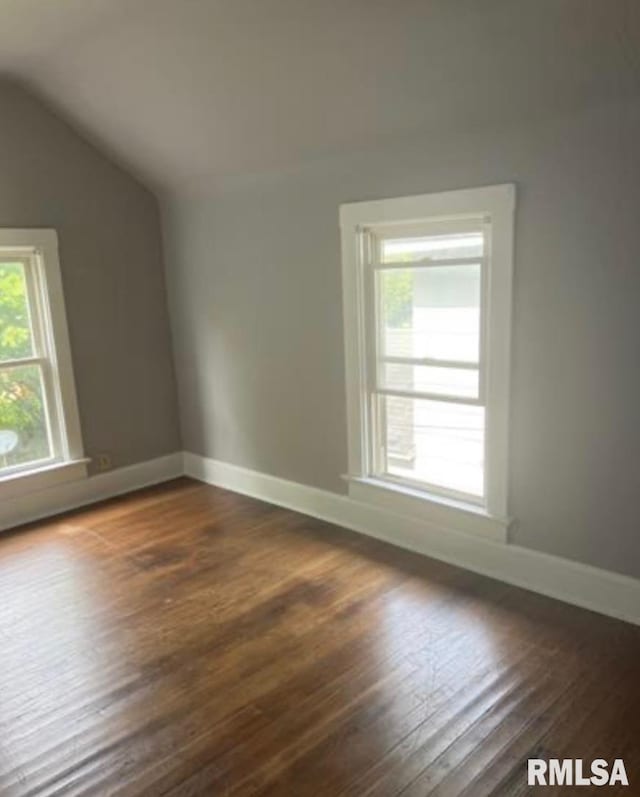 interior space featuring baseboards, dark wood-style flooring, and lofted ceiling