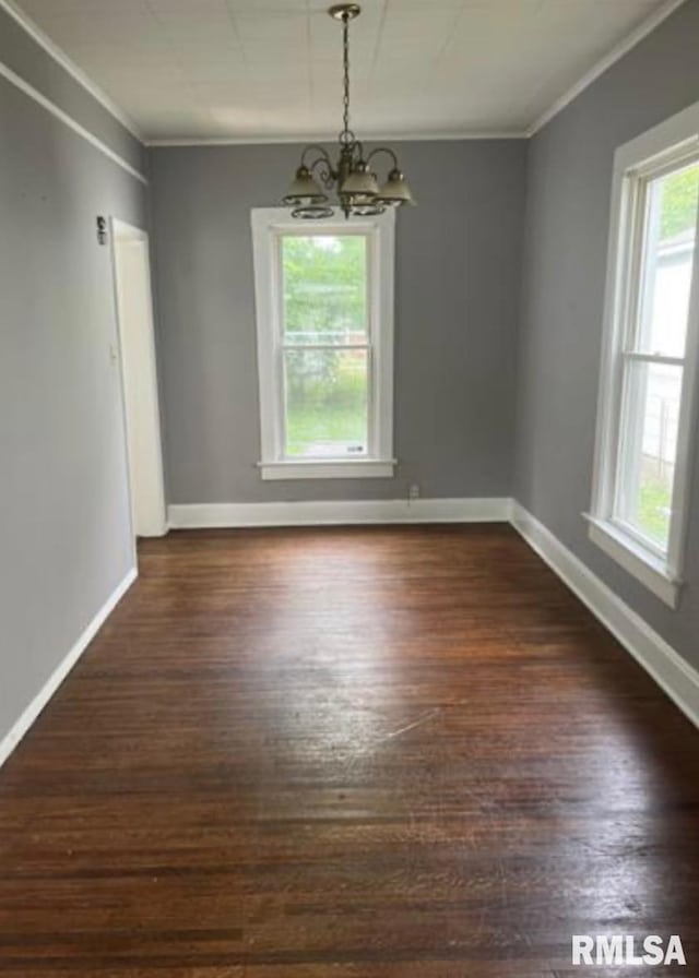 unfurnished dining area with crown molding, baseboards, dark wood-style flooring, and a chandelier