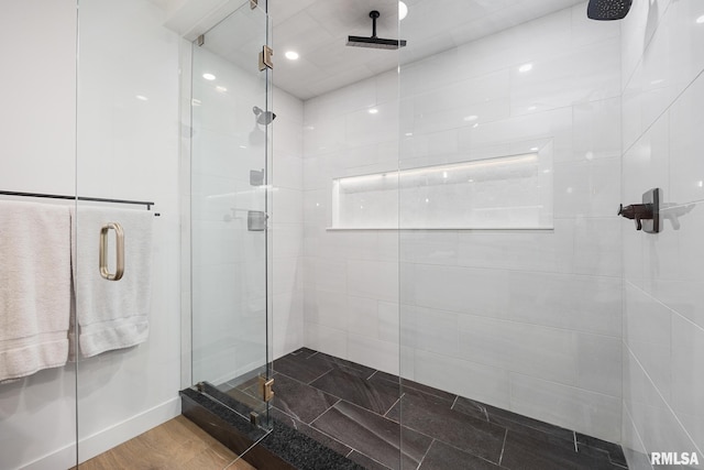 bathroom with a stall shower and wood finished floors