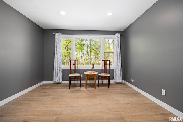 living area featuring recessed lighting, baseboards, and light wood-type flooring