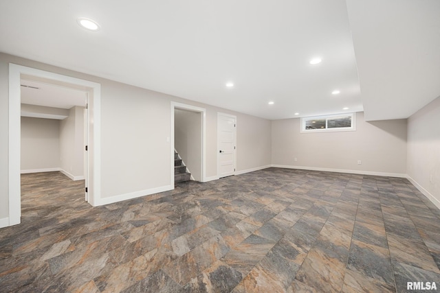 finished basement with stairs, recessed lighting, baseboards, and stone finish flooring
