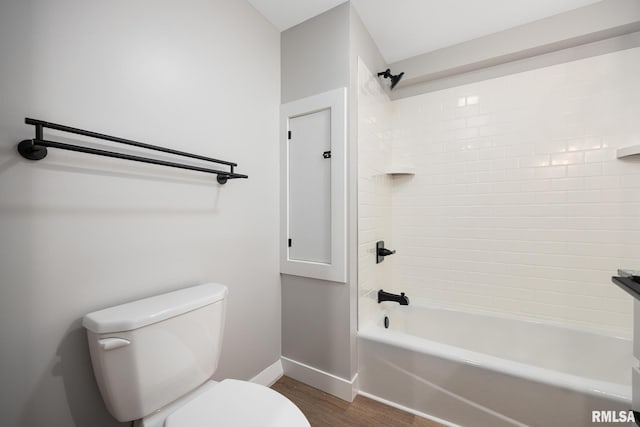 bathroom featuring baseboards, toilet, wood finished floors, and shower / tub combination