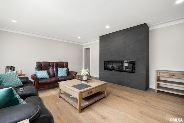 living area featuring light wood-type flooring, recessed lighting, a fireplace, and ornamental molding