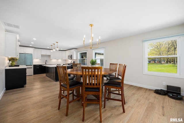dining area with a notable chandelier, light wood finished floors, recessed lighting, baseboards, and visible vents