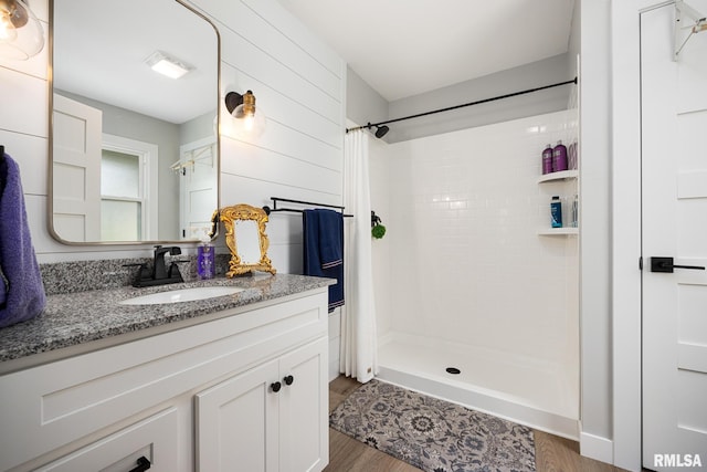 bathroom featuring vanity, a shower stall, and wood finished floors