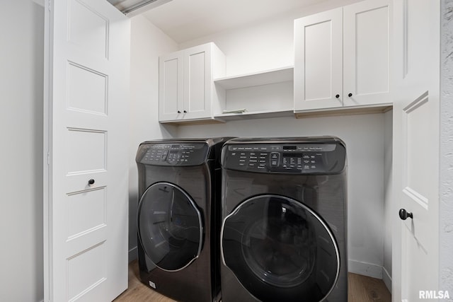 laundry area featuring independent washer and dryer, baseboards, and wood finished floors