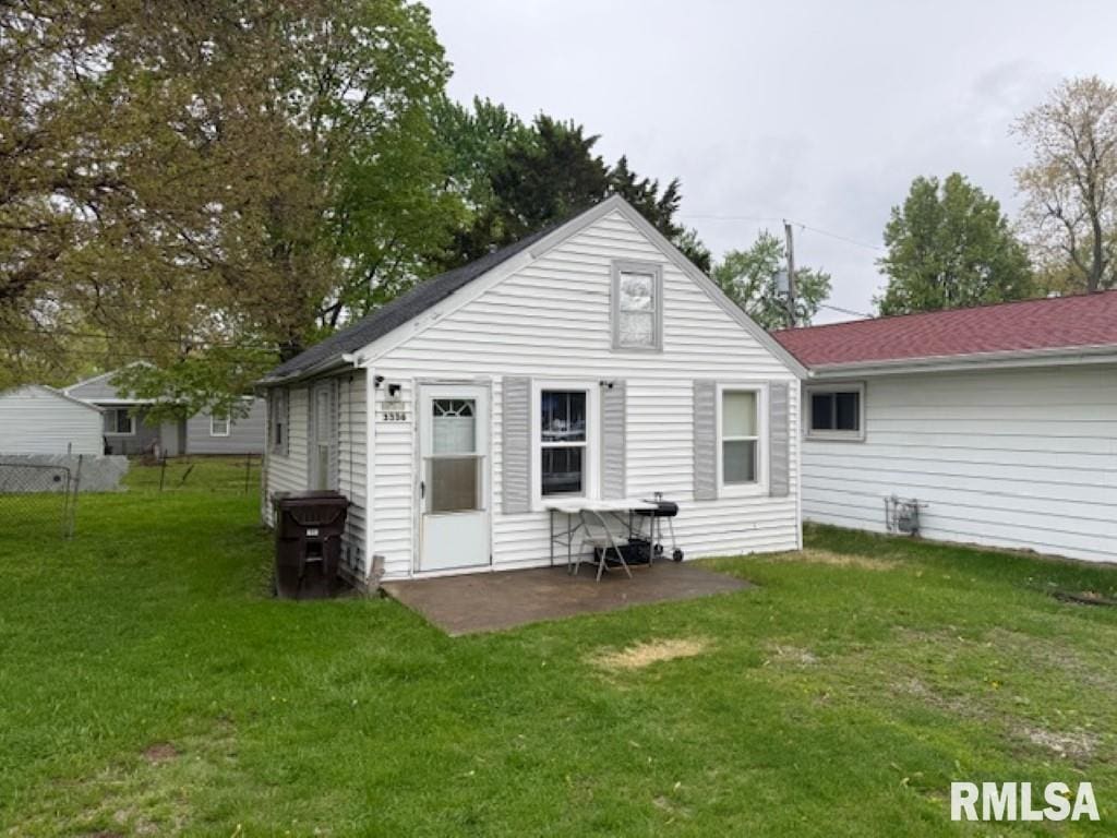 3336 N Sterling Ave, Peoria, IL 61604 - back of property featuring a lawn, fence, and a patio area
