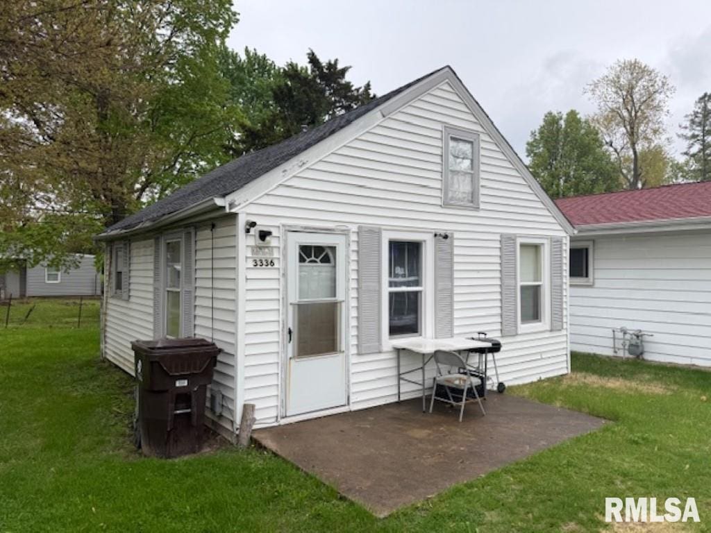 3336 N Sterling Ave, Peoria, IL 61604 - rear view of property with a lawn, a patio area, and roof with shingles