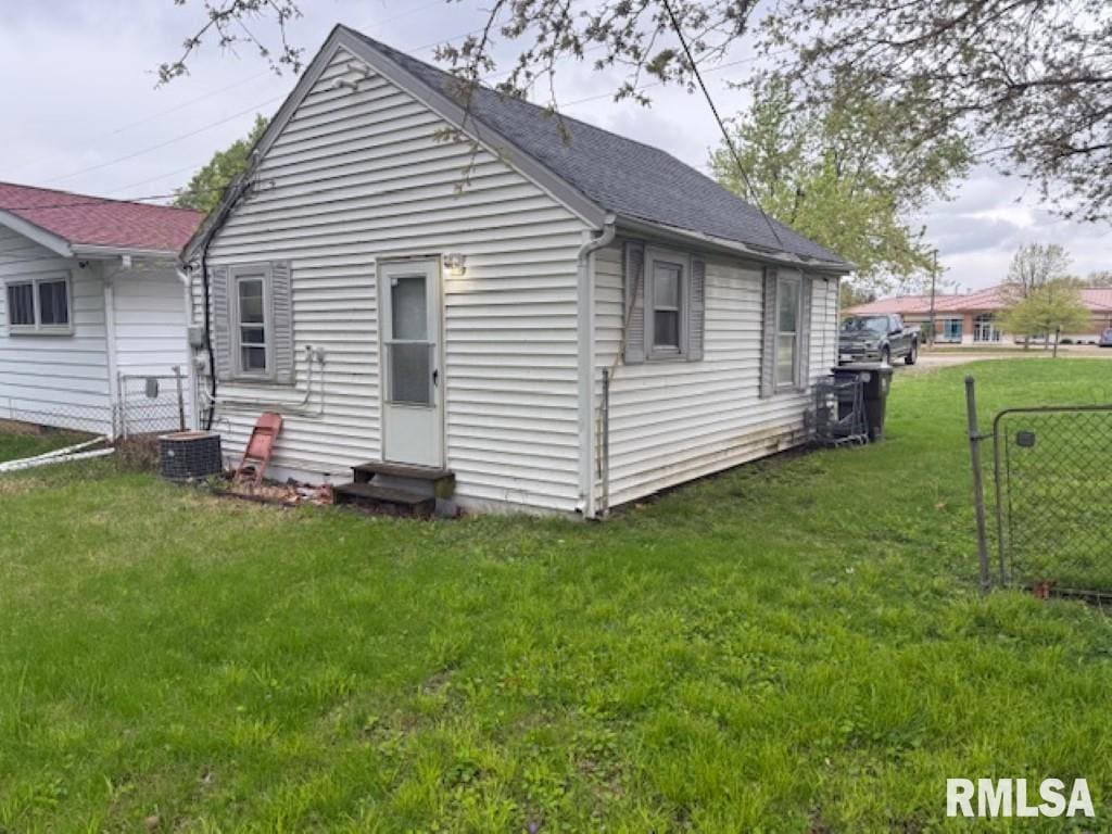 3336 N Sterling Ave, Peoria, IL 61604 - back of house featuring a lawn, roof with shingles, fence, and entry steps