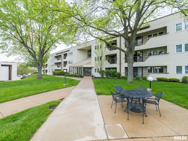 view of property's community with a patio, a yard, and outdoor dining space