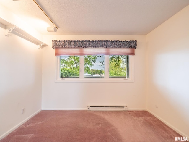 empty room featuring baseboards, carpet, a baseboard heating unit, and a textured ceiling