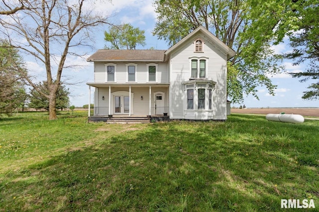 view of front of home with a porch, a front yard, and french doors