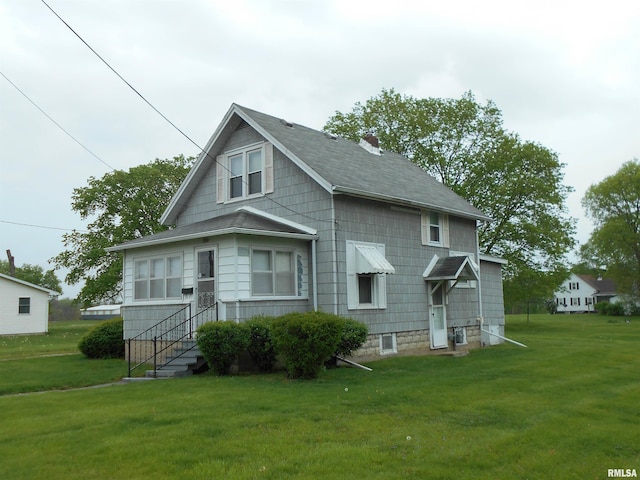 back of property with roof with shingles, a chimney, and a yard
