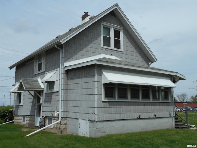 view of property exterior featuring a lawn and a chimney