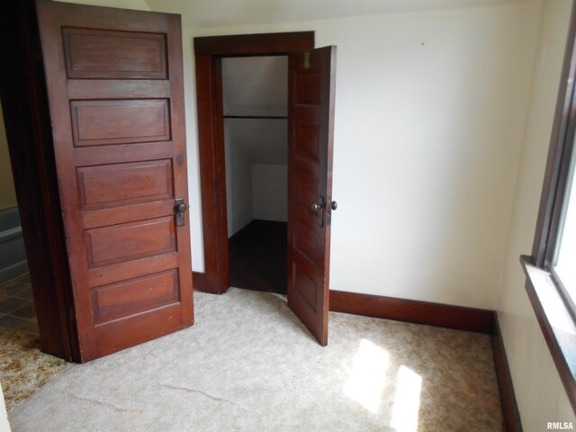 unfurnished bedroom with baseboards and light carpet