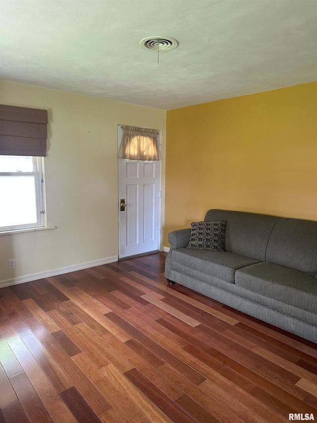 living room featuring baseboards, wood finished floors, and visible vents