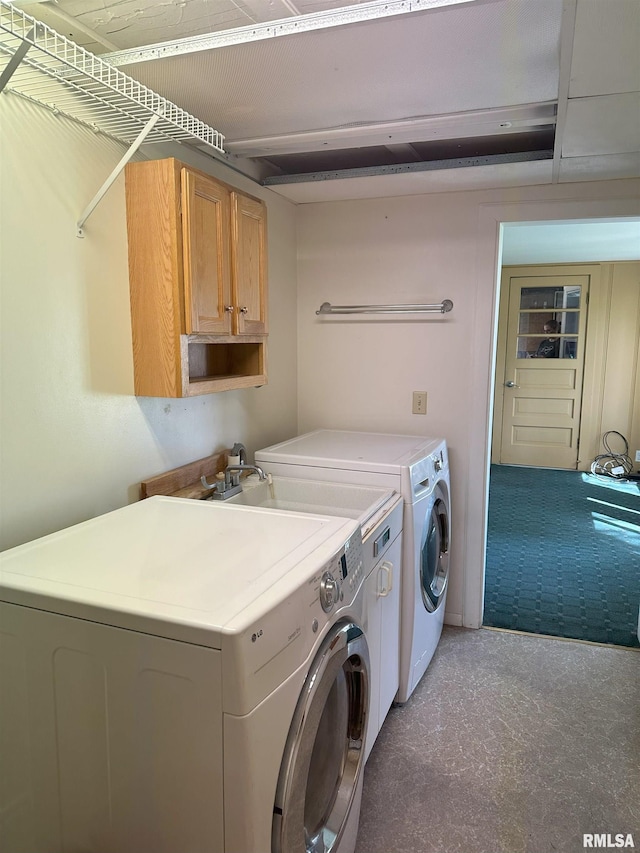 clothes washing area featuring separate washer and dryer and cabinet space