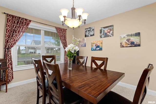 dining room with baseboards, an inviting chandelier, and carpet