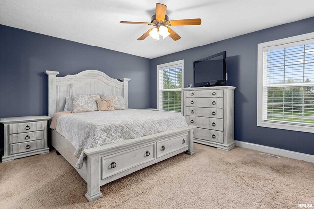 bedroom with a ceiling fan, baseboards, light colored carpet, and visible vents