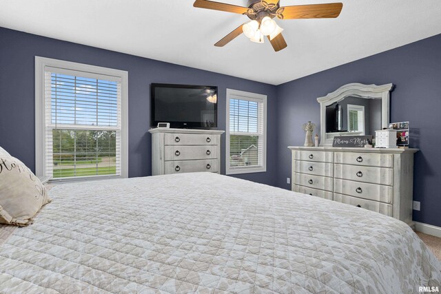 carpeted bedroom with baseboards and a ceiling fan