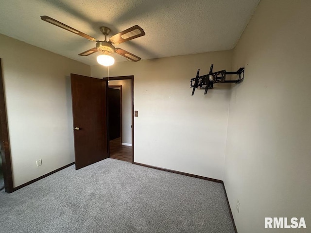 unfurnished bedroom with carpet floors, a ceiling fan, baseboards, and a textured ceiling