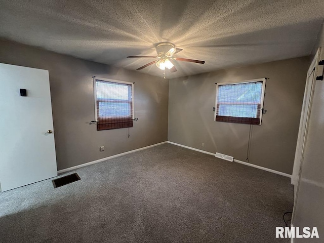 unfurnished room with baseboards, a ceiling fan, carpet flooring, and visible vents