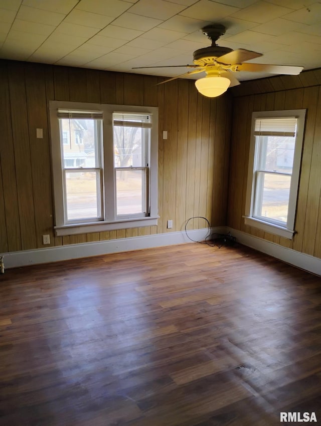 301 Cortland Ave, Avon, IL 61415 - empty room featuring baseboards, wood walls, dark wood finished floors, and a ceiling fan
