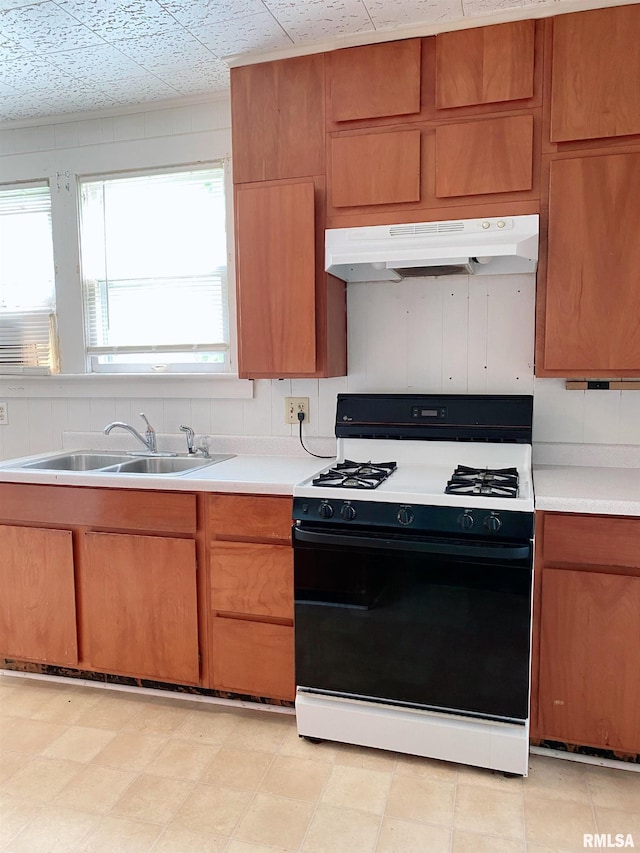 301 Cortland Ave, Avon, IL 61415 - kitchen featuring black gas range, under cabinet range hood, a sink, and light countertops