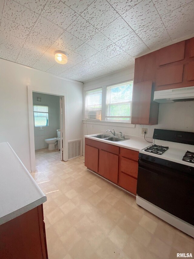 301 Cortland Ave, Avon, IL 61415 - kitchen with range with gas stovetop, under cabinet range hood, a sink, light floors, and light countertops