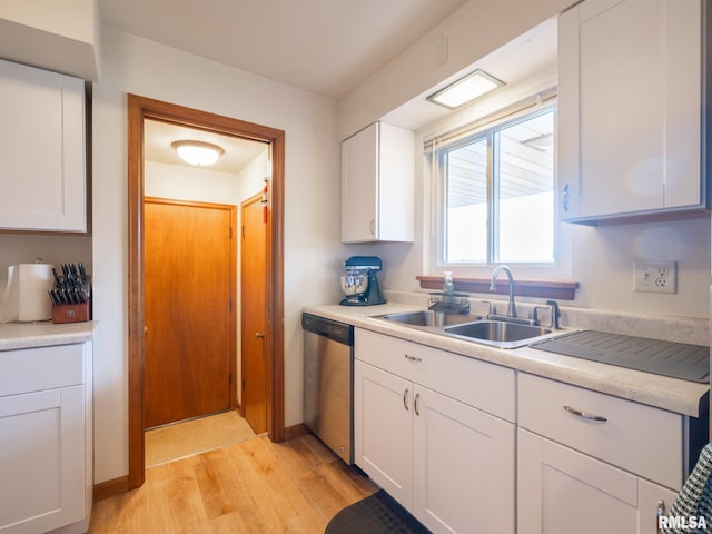 kitchen featuring white cabinets, a sink, light countertops, light wood-style flooring, and stainless steel dishwasher