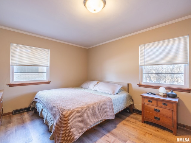 bedroom with crown molding, multiple windows, and light wood-type flooring