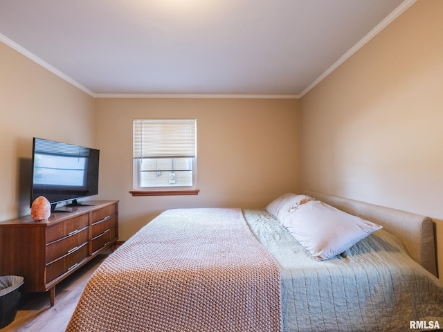 bedroom with crown molding and wood finished floors