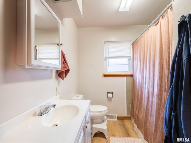 full bath with visible vents, wood finished floors, vanity, baseboards, and toilet