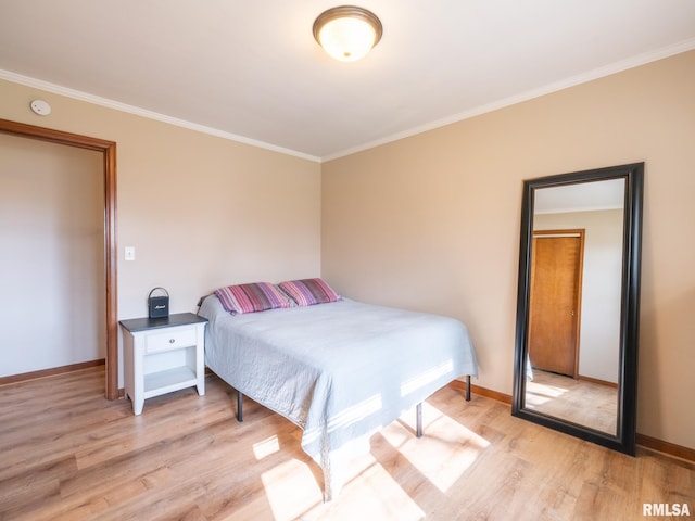bedroom with baseboards, ornamental molding, and light wood-style flooring