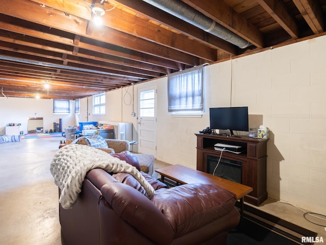 living room with concrete block wall, concrete floors, and a fireplace