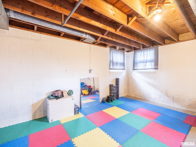 basement with concrete block wall, tile patterned floors, and wooden ceiling