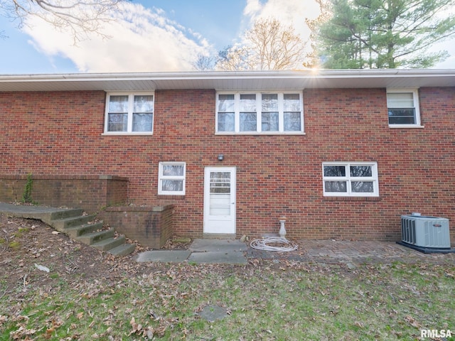 back of property featuring cooling unit, a patio area, and brick siding