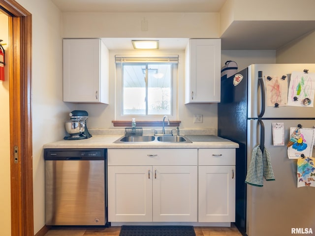 kitchen featuring light countertops, a sink, white cabinets, and stainless steel appliances