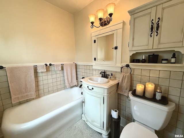 bathroom featuring vanity, toilet, a wainscoted wall, tile walls, and a bath