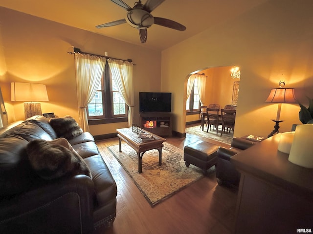 living area with a healthy amount of sunlight, arched walkways, a ceiling fan, and wood finished floors