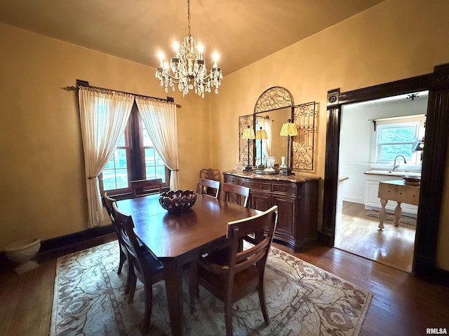 dining room featuring an inviting chandelier, baseboards, and dark wood-style floors