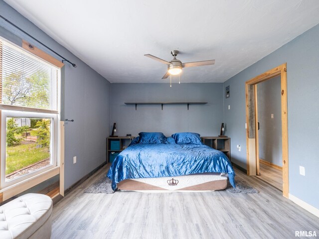 bedroom featuring baseboards, a ceiling fan, and wood finished floors