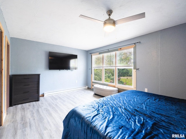 bedroom with a baseboard radiator, ceiling fan, and wood finished floors