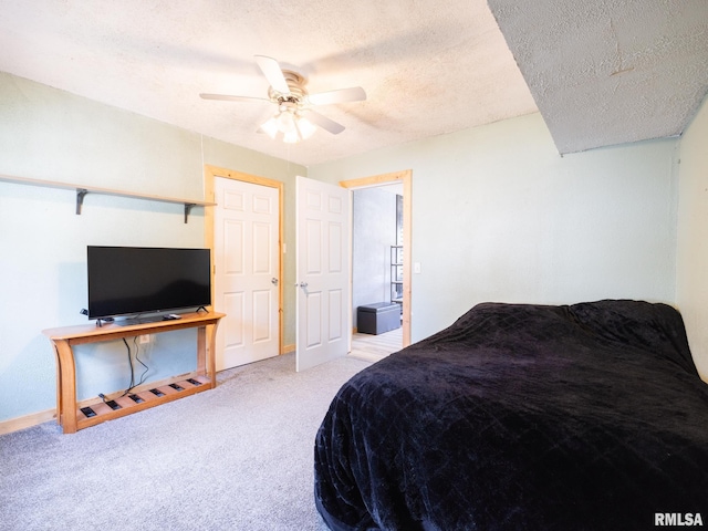 carpeted bedroom featuring ceiling fan and a textured ceiling