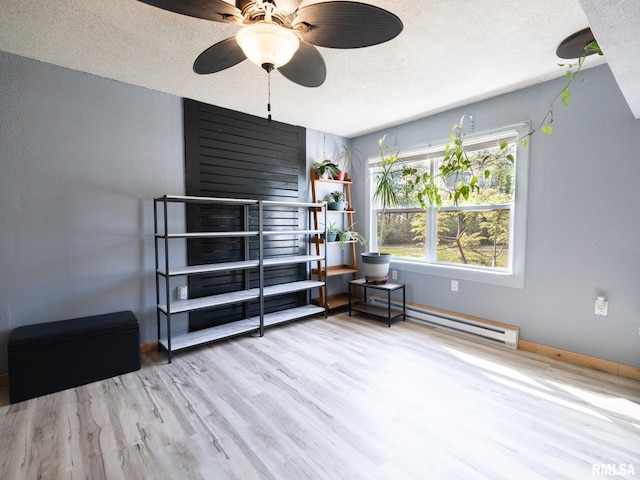 bedroom featuring a textured ceiling, baseboards, and a baseboard radiator