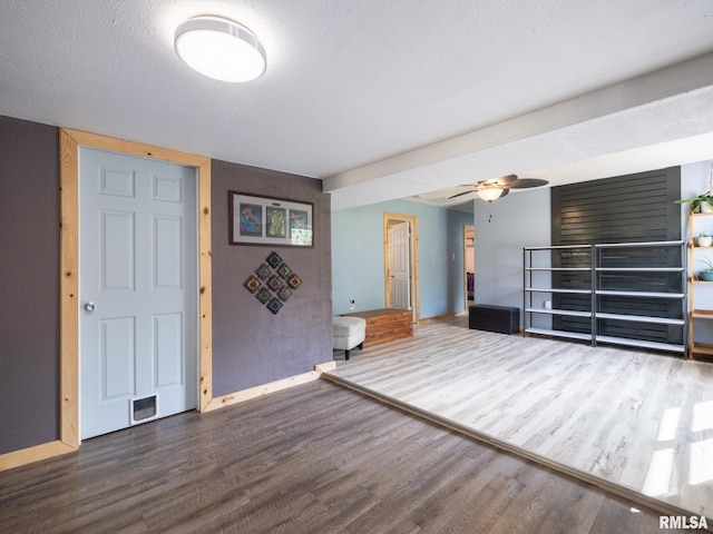 unfurnished living room with baseboards, ceiling fan, and wood finished floors